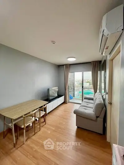 Modern living room with wooden flooring, cozy sofa, and dining area, featuring a balcony with city view.