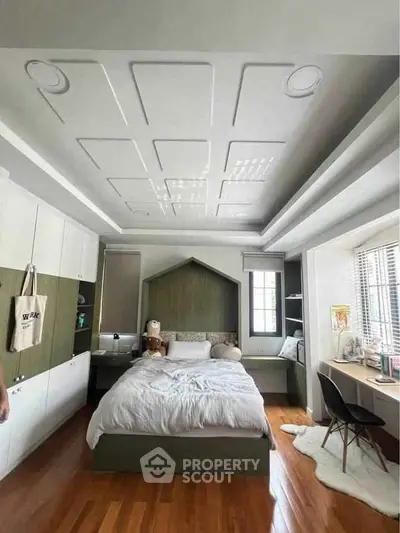 Charming bedroom with modern design, featuring a cozy bed, built-in storage, and a stylish workspace by the window.