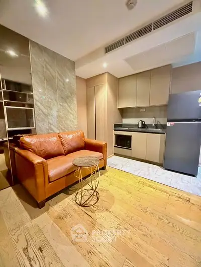 Modern living room with leather sofa and compact kitchen in stylish apartment