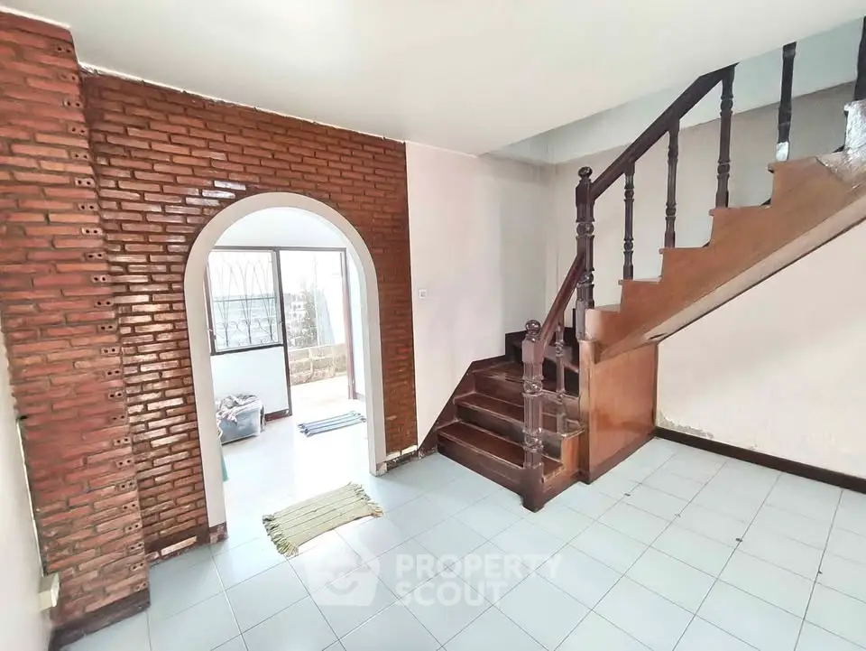 Charming interior with brick archway and wooden staircase in a cozy home