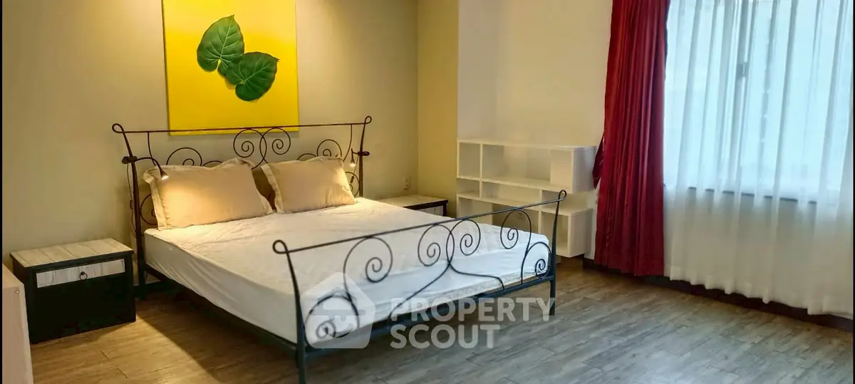 Spacious bedroom with elegant bed and large window for natural light.