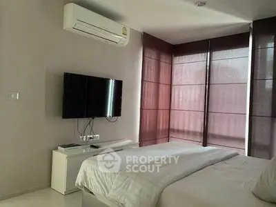 Modern bedroom with air conditioning and wall-mounted TV, featuring sleek blinds and minimalist decor.