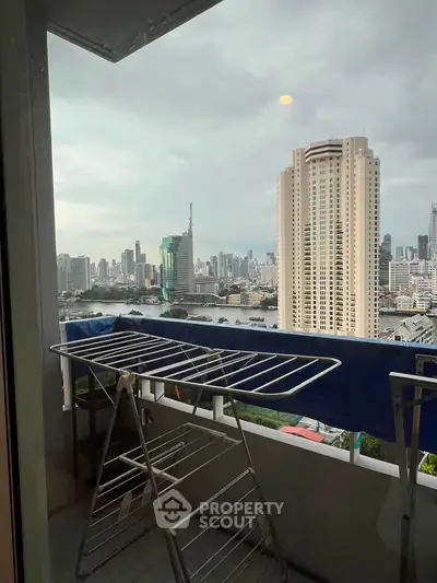 Stunning cityscape view from a high-rise balcony with laundry rack, perfect urban living experience.