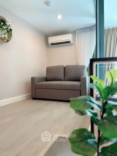 Cozy living room with modern sofa and air conditioning, perfect for relaxation.