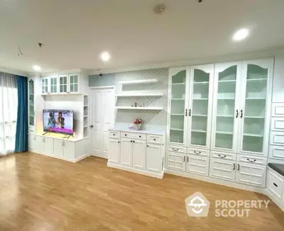 Spacious living room with elegant built-in cabinets and modern TV setup