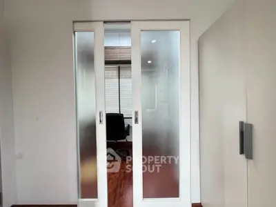 Modern study room with frosted glass sliding doors and wooden flooring