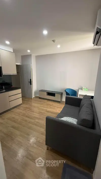 Modern living room with sleek furniture and wooden flooring in a cozy apartment.
