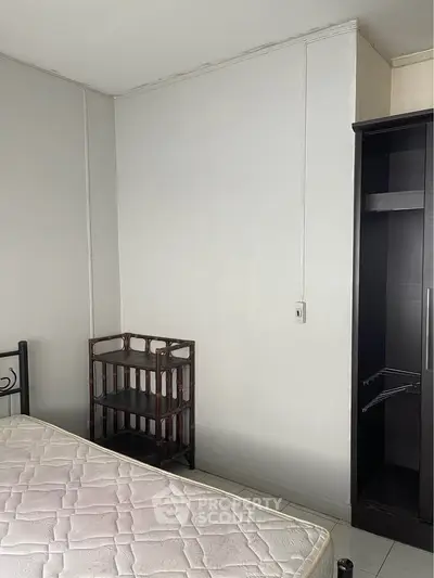 Minimalist bedroom with mattress and open wardrobe, ideal for customization.