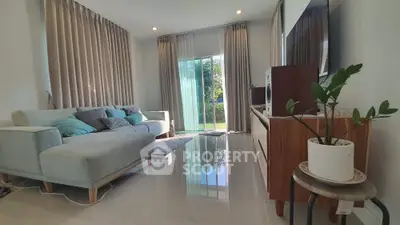 Spacious living room with modern decor and large windows overlooking garden