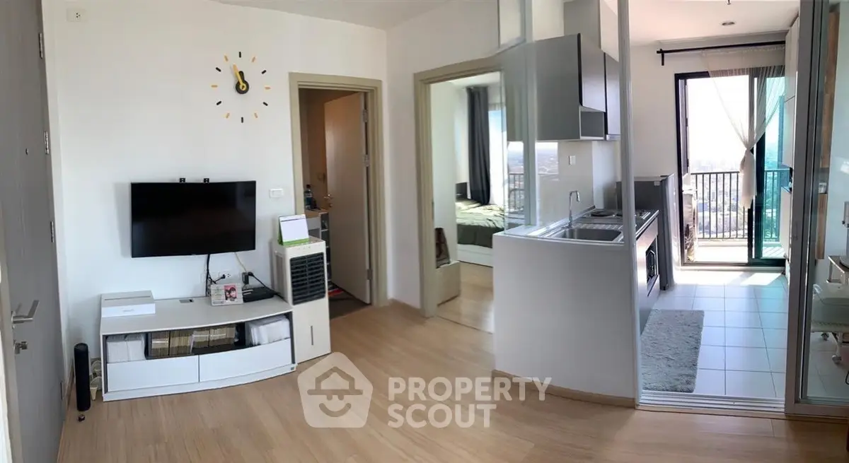 Modern apartment interior with open layout, featuring a cozy living area, sleek kitchen, and balcony access.