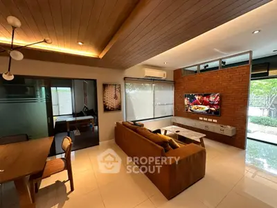 Modern living room with stylish decor, large windows, and a cozy seating area, perfect for relaxation and entertainment.