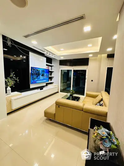 Luxurious living room with sleek modern design, featuring a large TV, comfortable leather sofa, and sophisticated lighting for an elegant ambiance.