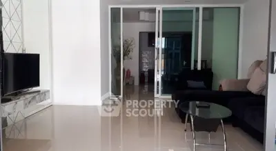 Modern living room with sleek glass doors and stylish furniture