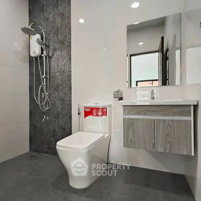 Modern bathroom with sleek fixtures and stylish design, featuring a shower and vanity.