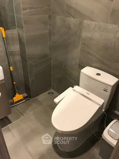 Modern bathroom with sleek gray tiles and contemporary toilet design