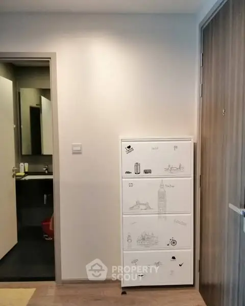 Modern apartment entrance with stylish shoe cabinet and bathroom view