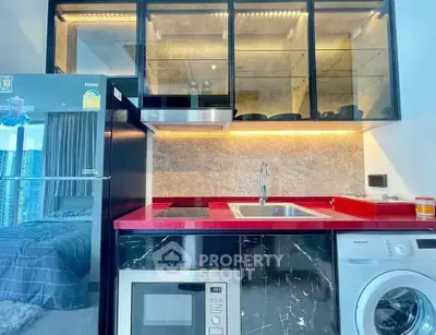 Modern kitchen with red countertop, washing machine, and city view from window.