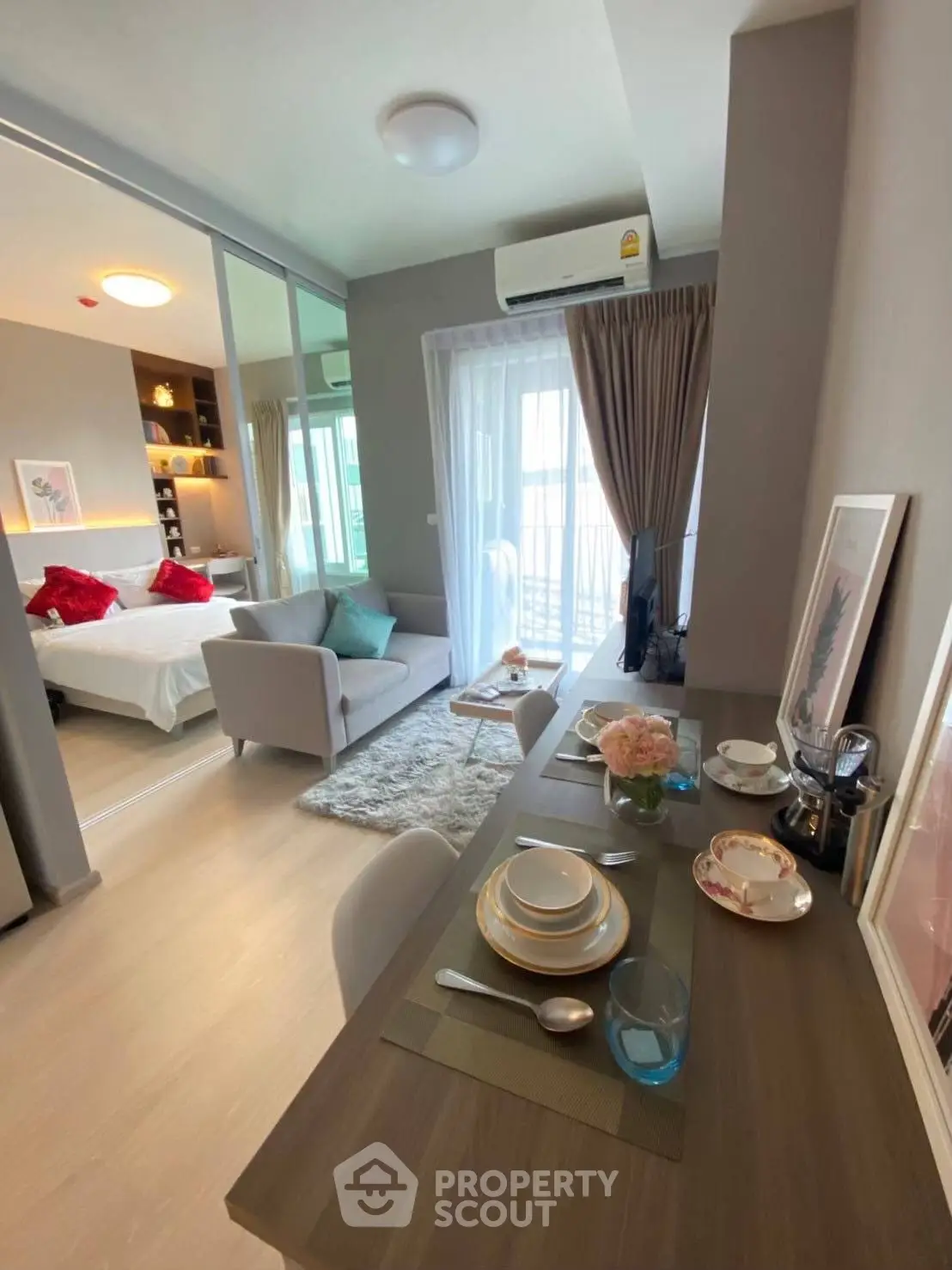 Modern open-plan living room with dining area and cozy bedroom view