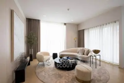 Elegant modern living room with stylish furniture and large windows.