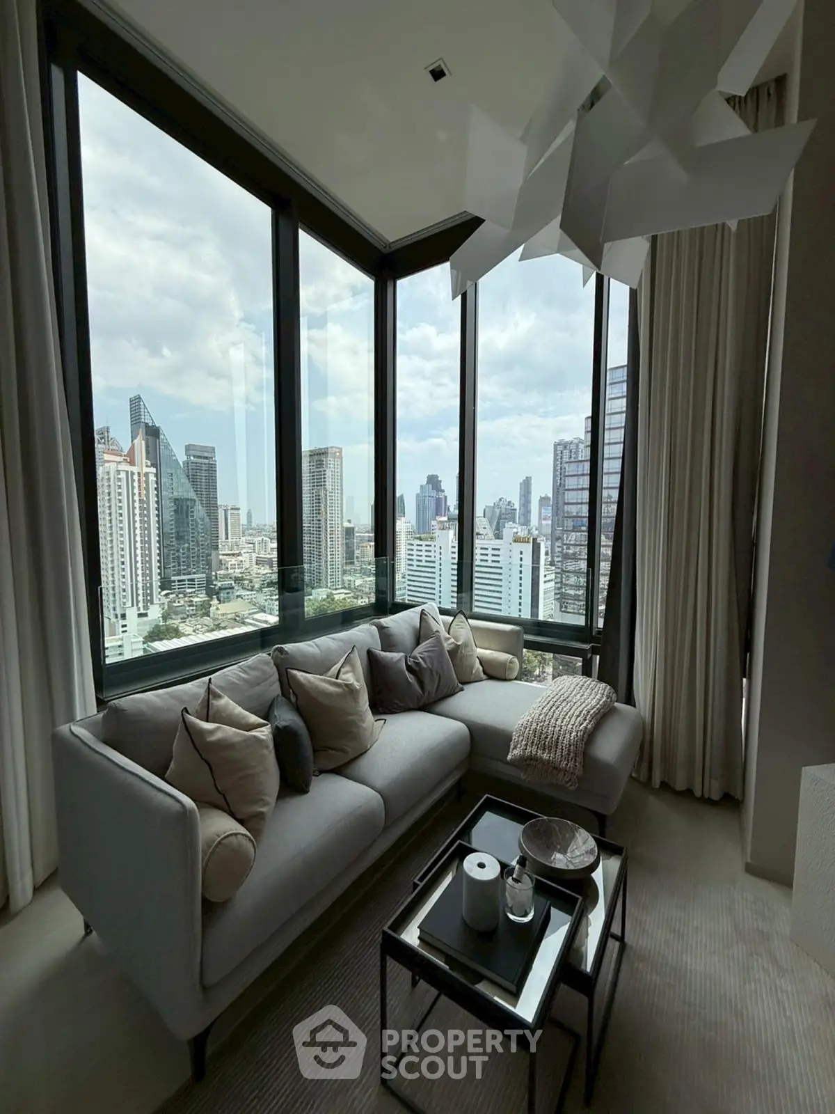 Luxurious corner living room with panoramic city views and modern decor.