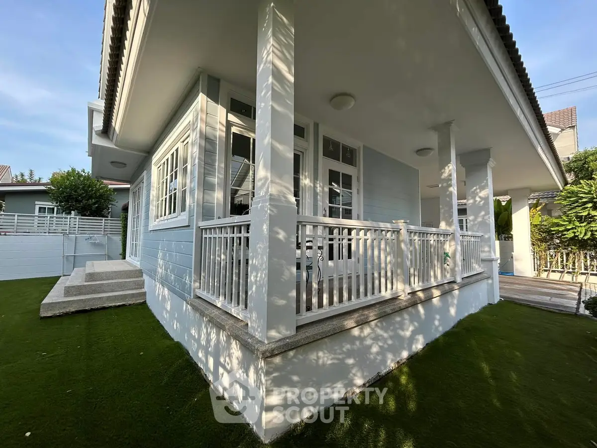 Charming corner unit house with spacious porch and lush green surroundings, perfect for serene living.