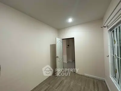 Spacious empty room with elegant wooden flooring and bright lighting, perfect for customization.