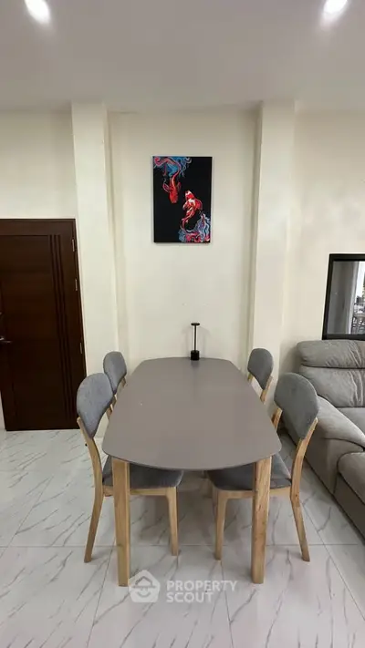 Modern dining area with sleek table and chairs, adjacent to a cozy living room, perfect for stylish urban living.