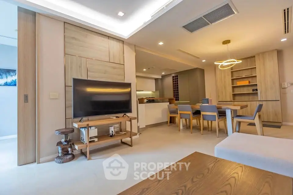 Modern living room with open kitchen, stylish furniture, and ambient lighting in a contemporary apartment.