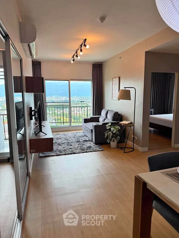 Modern living room with large window offering stunning city view, cozy seating, and stylish decor.