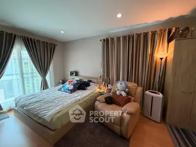 Cozy bedroom with plush armchair and elegant curtains, perfect for relaxation and comfort.