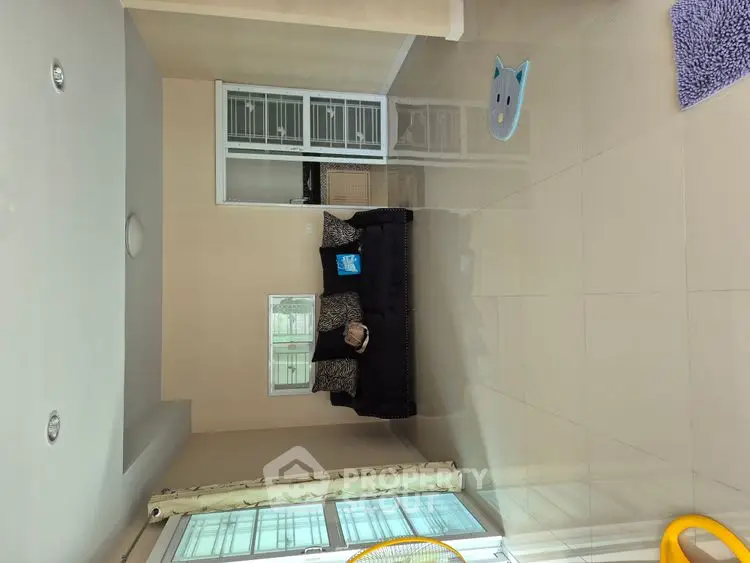 Spacious living room with modern sofa and large windows for natural light.