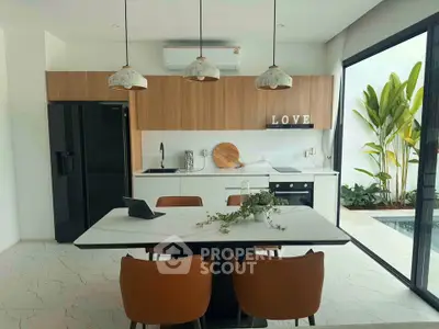 Modern kitchen with sleek design, open layout, and poolside view, featuring stylish pendant lights and elegant dining area.