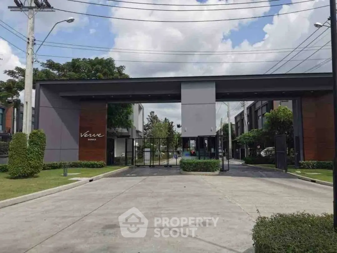 Modern gated entrance with sleek design and lush greenery