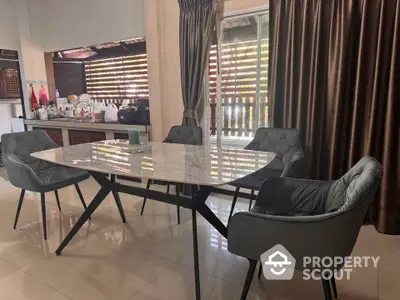 Stylish dining area with modern chairs and marble table in a cozy home setting.