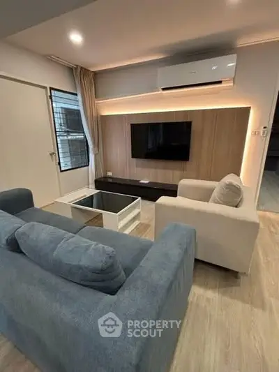 Modern living room with stylish furniture and wall-mounted TV