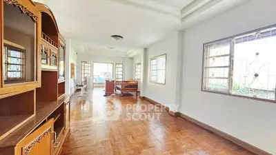 Spacious living room with wooden flooring and ample natural light, perfect for family gatherings.