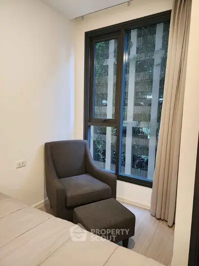 Cozy bedroom corner with armchair and window view in modern apartment