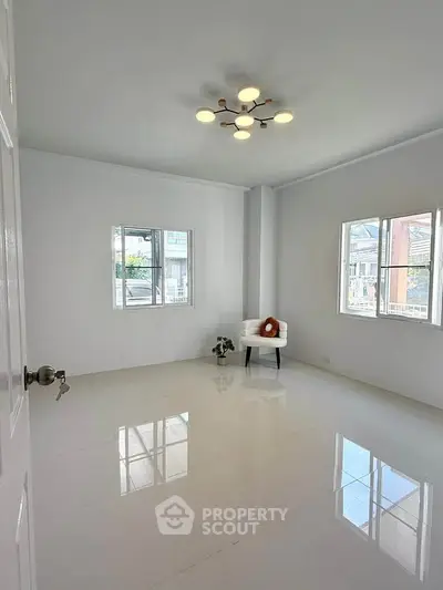 Bright and spacious empty room with modern lighting and large windows