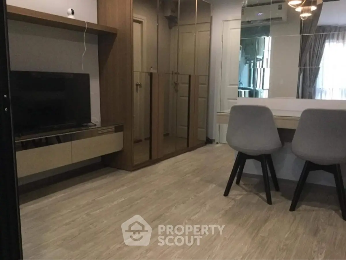Modern living room with stylish furniture and mirrored wall enhancing space