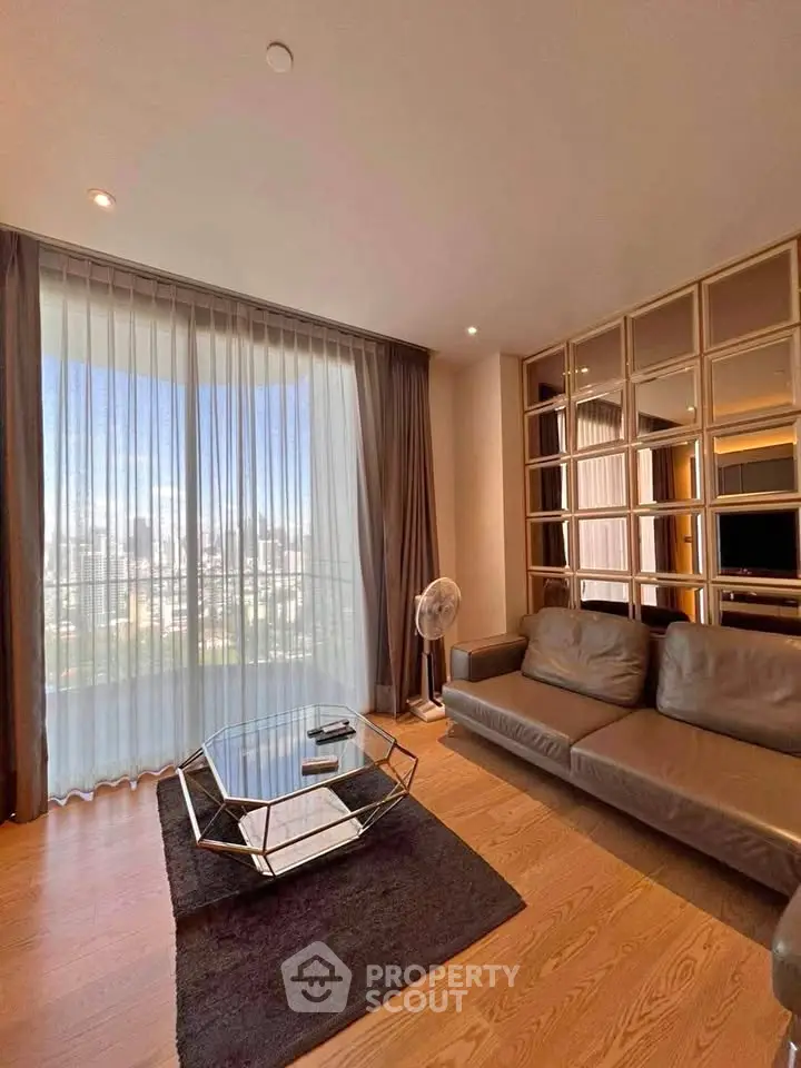 Modern living room with large window and stylish furniture offering city views.