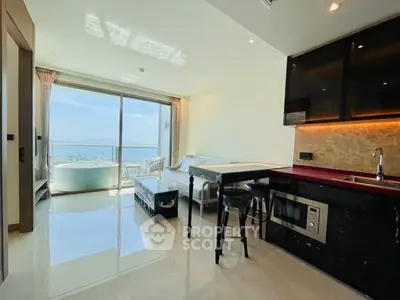 Modern open-plan living room with ocean view and sleek kitchen design.