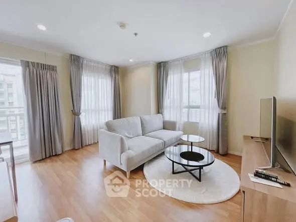 Spacious and bright living room with modern decor and large windows.