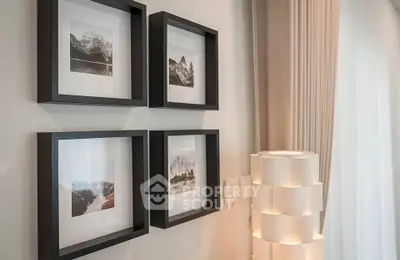 Elegant interior with framed art and modern lamp in a stylish living room.