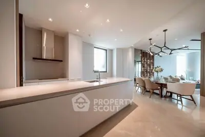 Luxurious open-layout kitchen and dining area with modern design and elegant lighting.