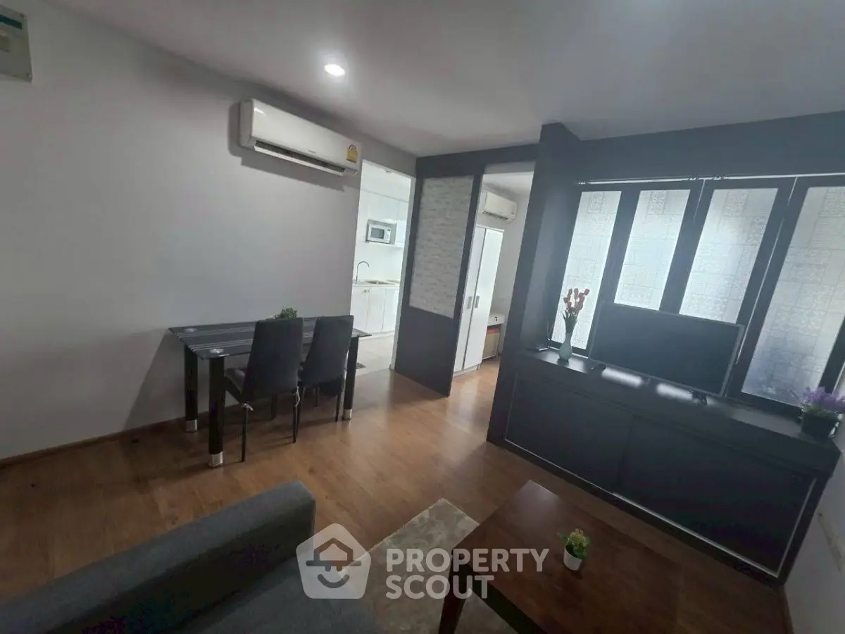 Modern living room with dining area and kitchen in open layout apartment.
