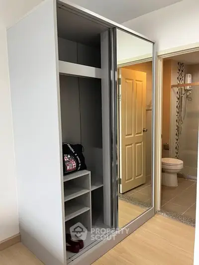 Modern bedroom with mirrored wardrobe and view into bathroom