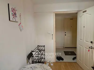 Cozy apartment entrance with open door and shoe rack, inviting ambiance.