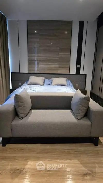 Modern bedroom with stylish decor and cozy seating area, perfect for relaxation and comfort.