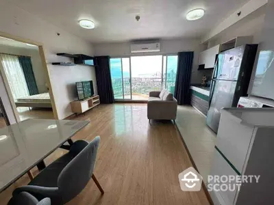 Spacious modern living room with balcony and city view in high-rise apartment.