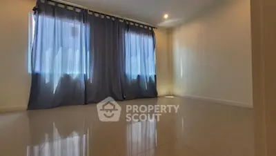 Spacious and well-lit living room with glossy tiled flooring and elegant dark curtains, perfect for modern living.